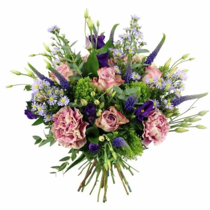 This image shows a generously proportioned, hand-tied bouquet laid out against a bright white background, allowing every nuance of colour and texture to stand out clearly. The main impression is of soft, romantic pinks and purples, carefully layered by an experienced florist so the eye moves easily across the design. Full-headed roses in blush pink and mauve form the central focus, some tightly furled like promise-filled buds, others more open with delicately rolled petals that graduate from deeper pink at the core to paler, almost creamy edges. Interwoven with them are large, frilled carnations in complementary dusty rose and muted mauve shades, creating plush, cushiony textures that give the bouquet its luxurious volume. Shooting up through the softer shapes are multiple spikes of deep lavender and indigo Veronica, adding height and a slender, architectural line that keeps the arrangement from feeling heavy. Surrounding and softening these are clouds of aster-like flowers in pastel lavender and periwinkle, each with a tiny yellow centre that brightens the ensemble, along with a few bell-shaped lisianthus blooms in more intense purple that add satisfying depth. The greenery is just as considered: rounded, silvery eucalyptus leaves mingle with softer green foliage, while clusters of vivid, almost chartreuse textural filler offer a playful contrast, like fresh spring growth along the paths leading out of Epping towards the forest. The bouquet is shaped in a classic rounded dome, with flowers gently spilling outwards in a natural, abundant style, and the cleanly cut stems are gathered tightly at the base, showcasing the hand-tied craftsmanship. It feels ideal for marking a special moment-a milestone birthday, a meaningful anniversary, or a heartfelt thank-you-delivered fresh to homes and businesses across Epping.