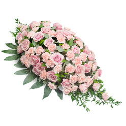 An elegant sympathy spray in soft pink tones lies on a clean white backdrop, shaped in a classic teardrop that is full and rounded at the upper left and then gently narrows to a tapering point on the lower right. The heart of the design is a dense gathering of blush pink roses, many of them in full bloom with layered, spiralling petals that feel almost velvety to the touch. Interspersed among them are lighter peach-pink carnations, their finely ruffled edges adding delicate movement and a slightly feathery texture. Some roses are just beginning to open, creating subtle variations in height and shade, from very pale pastel to slightly deeper dusty rose, giving the arrangement a soft, natural gradient. Cradling the flowers is an abundance of deep green foliage, with broad, ovate leaves forming a strong base along the central spine of the spray, and slimmer, pointed sprigs extending outward to soften the outline. From the lower right tip, a few strands of greenery trail gracefully, as if the flowers are gently flowing downward. The overall impression is serene and comforting, like a quiet walk along Epping High Street on an early Sunday morning. The spray looks perfectly suited for a casket, church lectern, or memorial stand, offering a visual embrace of compassion to grieving family and friends. Crafted with the care of an experienced local florist, this design speaks of respect, gentle farewell, and the enduring warmth of shared memories.
