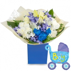 A carefully composed celebration of new life, arranged with the quiet confidence of a local Epping florist: a generous, round bouquet nestles in a deep, royal-blue rectangular presentation box, photographed on a clean white surface so every hue reads clearly. The arrangement balances classic whites and spirited blues-silky white roses at the centre, elegant white lilies partly in bud to suggest beginnings, and full white chrysanthemums that bring a soft, textural base. Bright, electric-blue chrysanthemums punctuate the bouquet, their saturated petals forming a vibrant core that draws the eye, while clusters of soft lavender or periwinkle bell-shaped blooms-reminiscent of hyacinth-add a subtle, powdery aroma and gentle contrast. Fresh green leaves and delicate fern fronds weave through the blooms, lending structure and a garden-fresh scent. The stems are wrapped in crinkled cream-coloured paper gathered at the base, creating a tactile, gift-like finish. Floating to the right, a light-blue foil baby carriage balloon, detailed with darker-blue canopy accents, heart motifs and polka-dotted wheels, declares It's a Boy in playful yellow-green letters and completes the celebratory tableau. Prepared with care for newborn visits, baby showers or a surprise on Epping High Street, this bouquet is something our team at Flowers Epping would happily ready for same-day local delivery across Epping and nearby Theydon Bois, Loughton and Buckhurst Hill-fresh, fragrant, and unmistakably joyful.