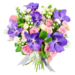 Set against a clean white backdrop, this breathtaking bouquet unfolds like a story of contrast and harmony, crafted in the style you might find in a favourite Epping flower shop near the High Street. Rich purple Vanda orchids command attention, their broad petals washed in velvety violet and indigo tones, etched with intricate speckles that resemble fine porcelain patterns. These tropical stars stretch confidently over a bed of soft, romantic blooms: pastel pink roses, some still cupped in shy buds, others generously open, revealing swirls of layered petals. Creamy white spray roses are threaded between them, creating pockets of light that gently lift the deeper colours. Scattered throughout are delicate tufts of tiny white flowers and clusters of white hypericum berries, their smooth, round shapes adding an almost jewel-like texture. Wisps of silvery dusty miller foliage glide through the arrangement like soft mist on an early walk by Epping Forest, while glossy deep green leaves frame the entire bouquet, lending structure and a rich, garden-fresh feel. The stems are bound at the base with a semi-sheer ribbon that shimmers in shades of silver and lilac, its trailing ends echoing the opulence of the orchids above. The mood of the piece is sophisticated yet tender, ideal for sending love, congratulations, or a thoughtful birthday wish to someone in Epping or the nearby villages. Every element-from colour pairing to leaf choice-speaks of a florist's practiced hand, creating a design that feels both modern and deeply romantic, perfect for brightening a quiet home or gracing a special dinner table.