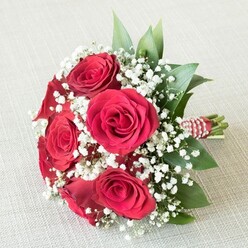 This sumptuous bouquet, crafted by a skilled Epping florist near the bustling High Street, weaves together the passionate allure of deep red roses with the gentle innocence of baby's breath. Each rose is a marvel-lush petals layered in tight spirals, gleaming with a richness only a fresh bloom can achieve. Between the roses, dainty white gypsophila flowers drift like morning mist over Epping Forest, their softness providing a luminous counterpoint to the intense crimson. Fresh ruscus and salal leaves, robust and gleaming, peek out and give the composition grounding and natural texture, bringing a breath of the outdoors into every petal. The bouquet's stems are expertly bound in a bold red and white ribbon, accented with a strand of miniature creamy pearls-a subtle nod to tradition and celebration. The bouquet reclines on a neutral, off-white canvas, its colours seeming to leap forward and invite the gaze. Warm daylight accentuates every curve and hue, creating an atmosphere both inviting and uplifting, much like a morning stroll through the heart of Epping. This bouquet is a harmonious choice for expressing affection, celebrating anniversaries, or marking life's meaningful milestones, embodying the elegance and thoughtful approach synonymous with our community. Perfectly suited for weddings in local venues or as a heartfelt delivery to homes near Bell Common or Ivy Chimneys, it captures the spirit of love that blossoms in Epping.