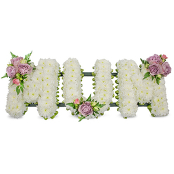 This carefully composed sympathy piece spells MUM in three upright letters, each letter entirely covered with dense, freshly cut white chrysanthemums that read like soft snow or a plush, tactile blanket of petals. The pristine white surface suggests calm and dignity under soft, even lighting, and the tiny composite flowers give the letters a uniformly textured, gentle relief. Delicate accent clusters of muted lavender and pale pink roses are placed with intention - one on the upper left arm of the first 'M', another nestling within the curve of the 'U', and a third crowning the upper right of the final 'M'. Some roses are fully open, their scent faint and honeyed, while others remain tight buds, offering the promise of unfolding memory. Interspersed bright green foliage and fern fronds breathe contrast and sculptural depth, their finer leaves creating delicate shadows across the white chrysanthemum field. At the base a dark green support, possibly ribbon-wrapped or mossed, outlines and stabilises each letter where small glimpses of darker framework appear beneath the blooms. The whole arrangement rests against a clean white backdrop that emphasises serenity and focus, making it suitable for a funeral chapel or wake at venues around Epping High Street or local crematorium services. The composition reads as a personal, heartfelt message of respect and remembrance - a floral spelling of love and farewell that a florist would describe aloud to someone unable to see, evoking texture, scent, and the quiet ceremony of mourning.
