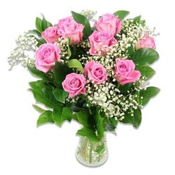 A delicately composed bouquet of baby flowers is shown in crisp detail against a spotless white background, centred around a lush gathering of soft pink roses that immediately evokes the happiness of welcoming a new baby. Around ten to twelve roses form the heart of the design, their petals unfolding in layered spirals that move from paler outer edges to deeper pink interiors, giving each flower an almost glowing, shell-like structure. Nestled among these romantic blooms are fine sprays of white baby's breath, each tiny blossom like a fleck of cloud, filling the gaps between roses and lending the whole display an airy, almost weightless quality. The foliage is a deep, glossy green, made up mainly of rose leaves that arch gently outwards, adding structure and a natural contrast that makes the pink and white tones shine. All of this is gathered into a clear glass vase, its simple, straight shape allowing the focus to stay entirely on the flowers while still revealing the submerged stems, freshly cut and held in clear water. The lighting is bright but soft, with no harsh shadows, so every petal and leaf looks fresh, cool, and newly arranged, as though just prepared in a local Epping flower shop for same-day delivery to a new family in Theydon Bois or near Epping Station. The overall impression is of gentle celebration and sweet affection - an ideal arrangement to accompany baby announcements, christening wishes, or 'welcome home' messages for a newborn girl.