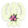 A reverent Sikh Khanda floral tribute dominates the image, resting against a spotless white background that highlights the careful craftsmanship in every petal. The entire emblem-the upright central sword, surrounding circular chakra, and the two outward-curving kirpans-is formed from countless small white chrysanthemums, each bloom fitted snugly against the next. Together they create a seamless, cushioned surface with a soft, almost wool-like texture, exuding the quiet calm often felt in Epping's more peaceful corners and family homes during times of mourning. The white flowers lean towards a gentle cream tone, suggesting natural freshness rather than stark artificiality. At the very base of the Khanda, where the tips of the kirpans nearly meet, a small but expressive cluster of accent flowers glows with colour. Three blush-pink roses, just opening to reveal their layered hearts, are accompanied by petite deep purple florets-possibly lisianthus or freesias-that deepen the palette without overwhelming it. Around them, sprigs of rich green fern and foliage emerge, their fine fronds adding movement and a touch of woodland grace reminiscent of the greenery around Epping Forest. The contrast between the serene white foundation and the intimate accent spray suggests both universal faith and personal love, making this a fitting choice for Sikh funerals, cremations, or memorial services in the local community. The subtle shadow cast below the tribute lifts it gently from the background, giving the impression of a cherished offering carefully laid in honour and respect.