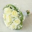 There's an airy joy and timeless elegance woven into this hand-tied bouquet-a favourite choice for ceremonies and celebrations in Epping. Luminous white and soft yellow roses rest together in perfect balance, petals unfurling with the kind of gentle radiance seen in early morning light drifting over Epping Forest. Wisps of snow-white gypsophila float between the blooms, casting an ethereal veil that softens the arrangement, while arcs of vibrant green bear grass create playful loops that frame the bouquet and add contemporary flair. The stems are bound with smooth silver ribbon, meticulously accented with rows of tiny white pearls that catch the light and beckon a gentle touch. Just visible below, the natural ends of the stems speak to the fresh, garden-picked character of the bouquet, lending it an authentic charm that feels as sincere as the local celebrations it accompanies. Imagine this bouquet graced in the hands of a bridesmaid or resting as an elegant centrepiece at an Epping anniversary gathering-its subtle fragrance, textural richness, and palette of gentle creams and greens offering a sense of calm, hope, and graceful artistry, lovingly crafted for special moments by your trusted local florist.