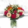 This Epping bouquet feels like a moment of pure celebration, frozen in time and filled with colour and life. The vibrant orange gerberas spread warmth through the arrangement, harmonising with soft blush roses and the rich, velvet textures of magenta carnations. Creamy ivory roses and tender, peach-toned gerberas provide an elegant counterpoint, lending a gentle serenity reminiscent of Epping's tranquil parklands. Glossy, robust foliage enfolds the blooms, creating a sense of lush abundance and framing the flowers with expert care. Bathed in luminous natural light-much like the soft glow filtering through local tearoom windows-the palette comes alive, each petal's delicate vein visible in the gentle brightness. This bouquet, expertly crafted by an experienced Epping florist, feels perfect for commemorating life's milestones or simply bringing a burst of happiness to someone special within the community. Its atmosphere is one of shared joy and harmony, echoing the welcoming spirit found throughout Epping's neighborhoods.