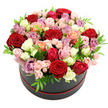 A round black hat box filled to overflowing with roses is captured here in crisp detail against a white studio background, giving the impression of a jewel-like object suspended in light. The arrangement forms a generous, rounded mound, each rose head nestled tightly against its neighbours so that the viewer sees almost nothing but petals and the smallest hints of green. Deep red roses anchor the palette with their classic, romantic richness, while blush pink and soft peach blooms create a gentle, flattering halo around them. Accents of vibrant fuchsia and warm coral add energy, and scattered throughout are creamy white and ivory roses that brighten the overall design. Subtle lavender and mauve roses tuck into the mix, adding cool undertones and a sophisticated, modern twist. Spray roses, in miniature clusters, are interspersed with the larger blooms, some perfectly open, others still in button-stage buds that hint at tomorrow's beauty. Glimpses of small, bright green leaves provide just enough contrast to keep the colours lively, without breaking the plush, continuous surface of petals. Around the base of the sleek black box, a slender line of red trim or ribbon underscores the romantic theme and ties in with the red roses above. The scene suggests a hand-crafted hat box arrangement ready for same-day delivery around Epping, perhaps to a home off the High Road or an office near the market, to celebrate an anniversary, an engagement, or a heartfelt thank-you. Every petal texture, from velvety to softly satiny, is visible, conveying a sense of freshness, care, and quiet luxury.