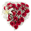 A carefully crafted heart-shaped bouquet sits against a pure white backdrop, its silhouette defined by a dense field of deep crimson roses. Each rose displays velvety petals in different stages of bloom-from tight, glossy buds at the heart's inner curve to broad, open blossoms at the outer contours-creating layered shadows and a tactile, plush surface you almost want to touch. Flecks and clouds of tiny white baby's breath (Gypsophila) weave through the red, softening the intense palette with a feathery lightness that lifts the composition and gives the heart a gently haloed edge. In the upper left curve a single, large white lily unfurls, its broad, pristine petals catching the light with a subtle satin sheen; a whisper of creamy yellow pools near its throat and the yellow-orange stamens add a warm, sculptural accent. The white background isolates the arrangement so every scarlet petal and delicate white floret reads with clarity, and the soft studio light highlights the roses' velveteen texture and the lily's smooth waxy surface. The overall feeling is intimate and sincere-romantic yet refined-a design suited for anniversaries, heartfelt tributes, or a timeless Valentine's gesture. I imagine this piece arriving fresh from our bench on Epping High Street after a morning of careful assembly, its scent a gentle blend of rose sweetness and the faintly spicy note of lily. The craftsmanship is deliberate: each bloom placed to maintain the heart's perfect symmetry while preserving natural movement, so the arrangement reads both as an emotive symbol and as a display of floral expertise rooted in local care.